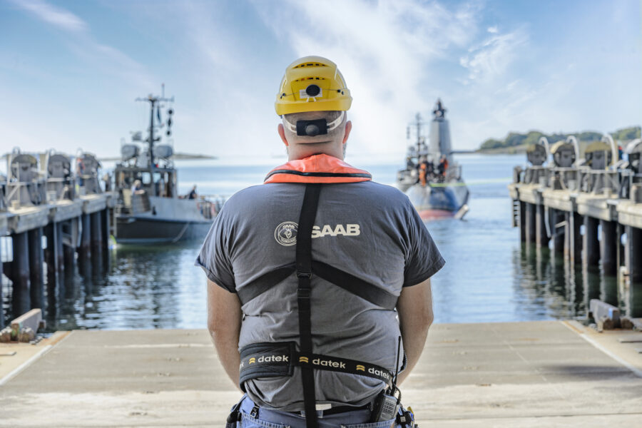en man med saabtröja och hjälm framför en hamn