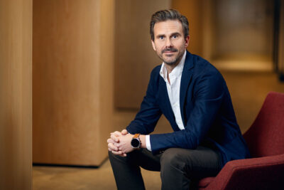 Andreas Stenbäck sitter i kostym på en soffa