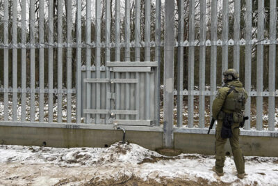 A Polish border guard looks east into Belarus at the crossing point Połowce-Pieszczatka in Polowce, Poland,