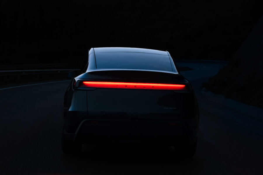 en tesla model y bakifrån i mörkret