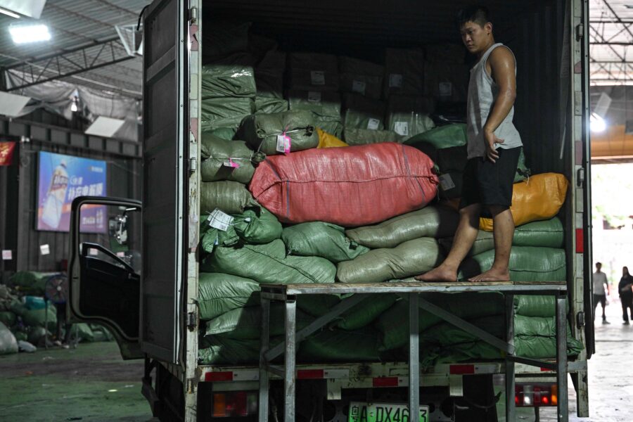 A man loads a truck with parcels at a warehouse of the Weijiang International delivery company that works with packages of Chinese-founded online shopping giant Temu in Guangzhou in China's southern Guangdong province on August 12, 2025. Sky-high US tariffs on Chinese goods overwhelmed the warehouse earlier this year and slowed the company's US-bound parcels to a trickle. But after US President Donald Trump announced on August 12 a truce on those duties would be extended, the depot in southern China's manufacturing hub Guangzhou was alive with noise as workers stuffed trucks with packages of clothes and kitchenware. (Photo by ADEK BERRY / AFP) / To go with 'CHINA-TARIFFS-ECONOMY-US, REPORTAGE' by Mary YANG